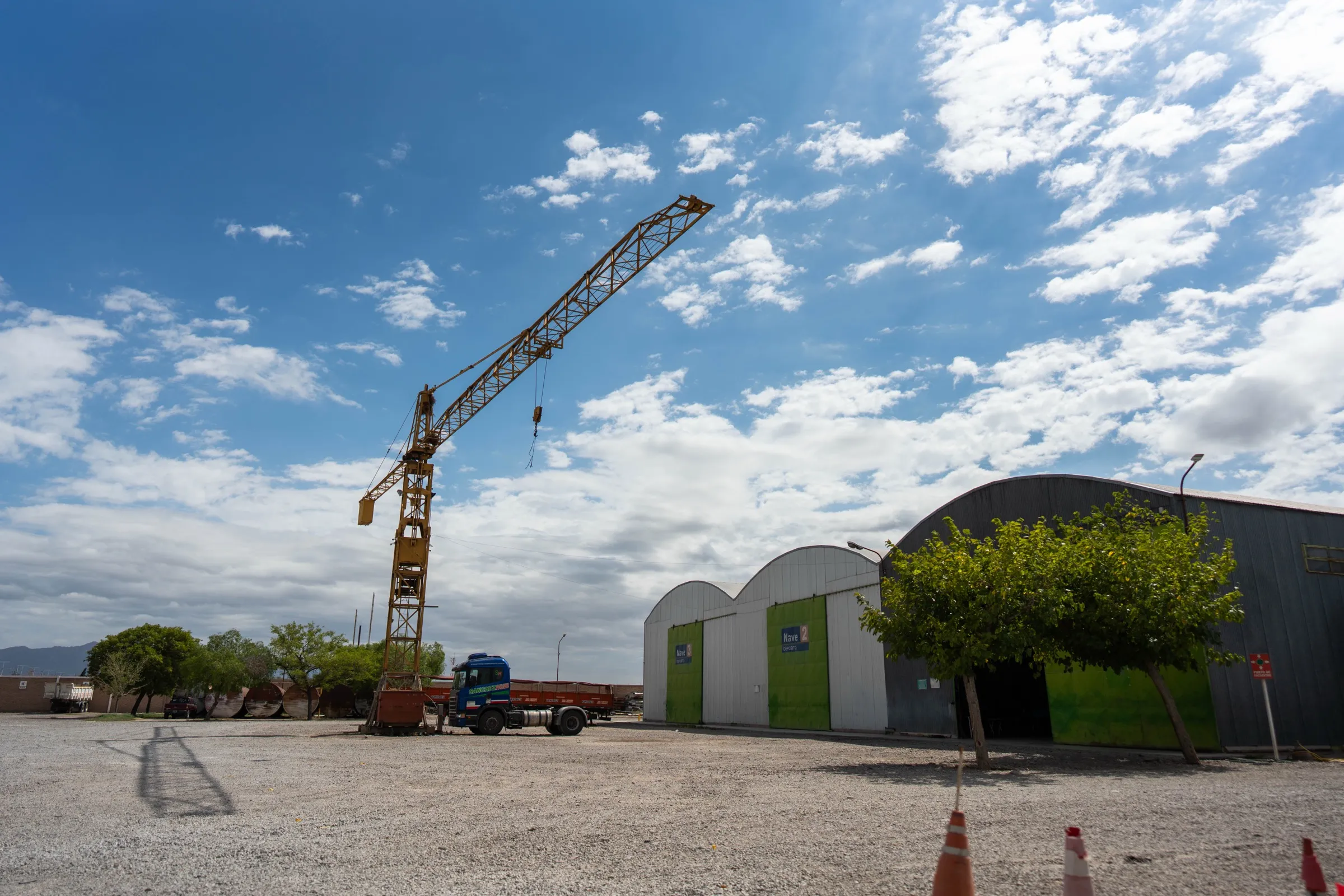 Otra vista de las naves de depósito del centro logístico de Chimbas, con la grúa torre y un camión estacionado en el predio